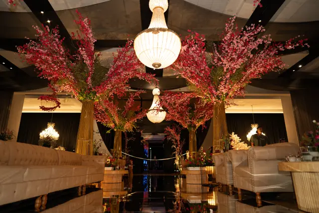 Lounge com sofás capitonê e árvores floridas